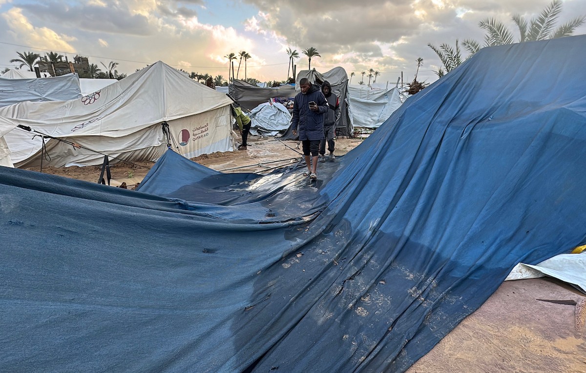 يُكافح الفلسطينيون النازحون، المقيمون في خيام مؤقتة، من أجل البقاء في ظل ظروف قاسية، حيث تجتاح الأمطار والعواصف الشديدة دير البلح، وسط قطاع غزة، في 28 ديسمبركانون الأول 2025. صورة أحمد إبراهيم(APA)