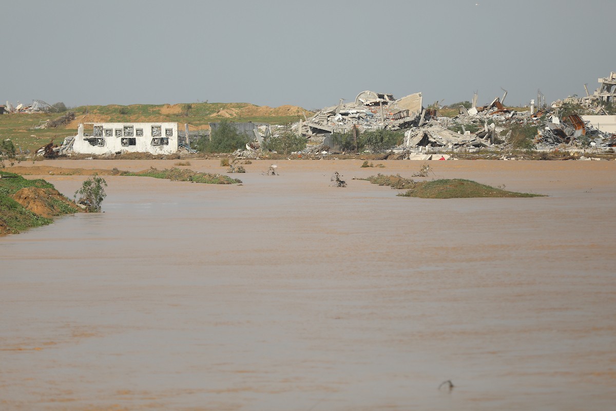 فتح الجيش الإسرائيلي مجرى وادي غزة، مما أدى إلى ارتفاع منسوب المياه إلى مستوى الجسر. وقد فاقم هذا الوضع معاناة العائلات النازحة التي كانت تقيم في خيام بالمنطقة بعد أن فاض الوادي وجرف خيامها، 29 ديسمبر/كانون الأول 2025. صورة: رمزي أبو عامر