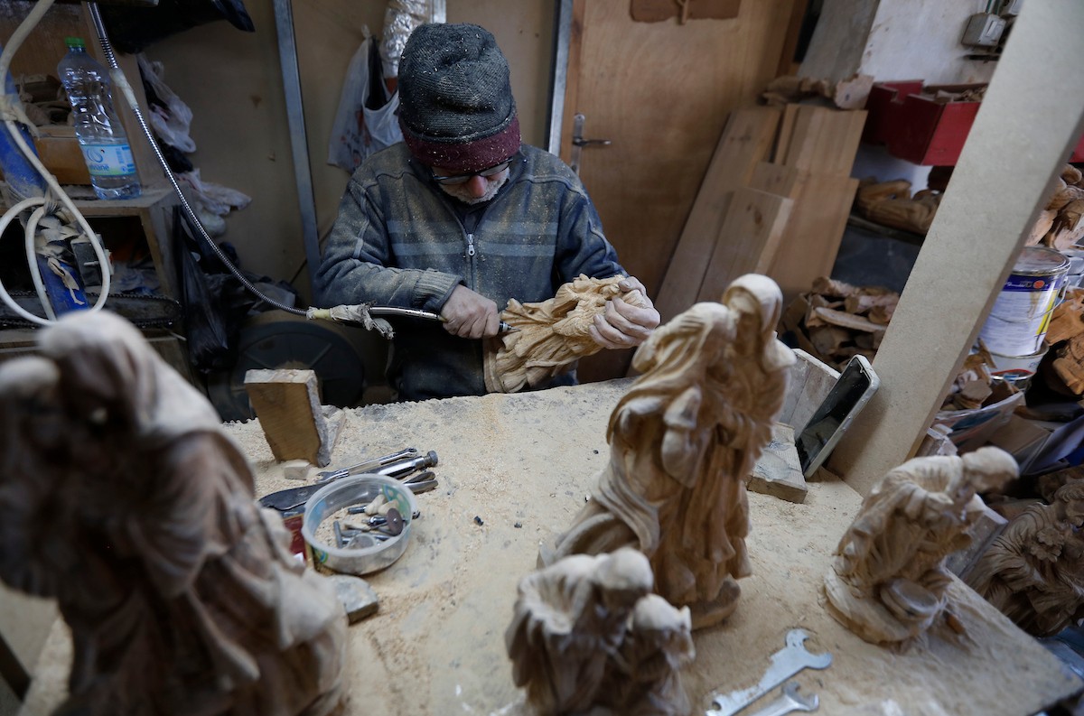 نحت خشب الزيتون في بيت لحم لصنع قطع فنية وهدايا متنوعة، تشمل منحوتات دينية وزخارف تقليدية وتذكارات، استعدادًا لعيد الميلاد، 18 ديسمبر/كانون الأول 2025 تصوير: مأمون وزواز/ (apa)