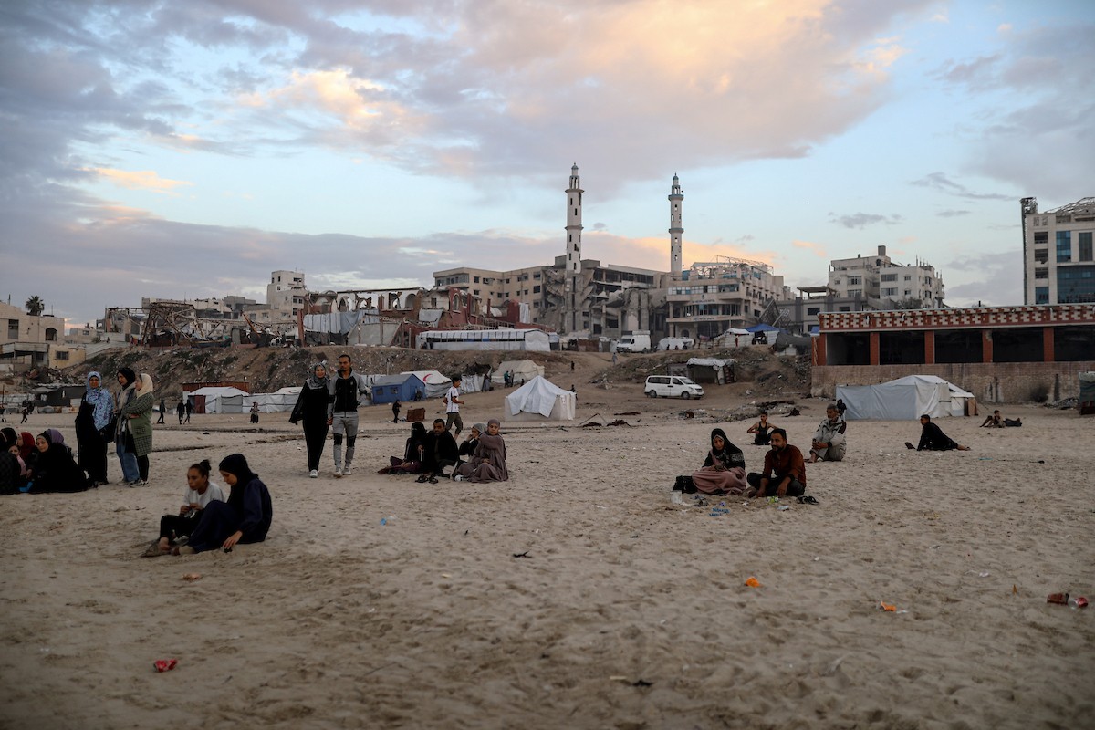 يقضي فلسطينيون نازحون وقتًا على الشاطئ مقابل خيامهم الممتدة على طول ميناء غزة، في غزة، 5 ديسمبر/كانون الأول 2025. تصوير: عمر أشتوي