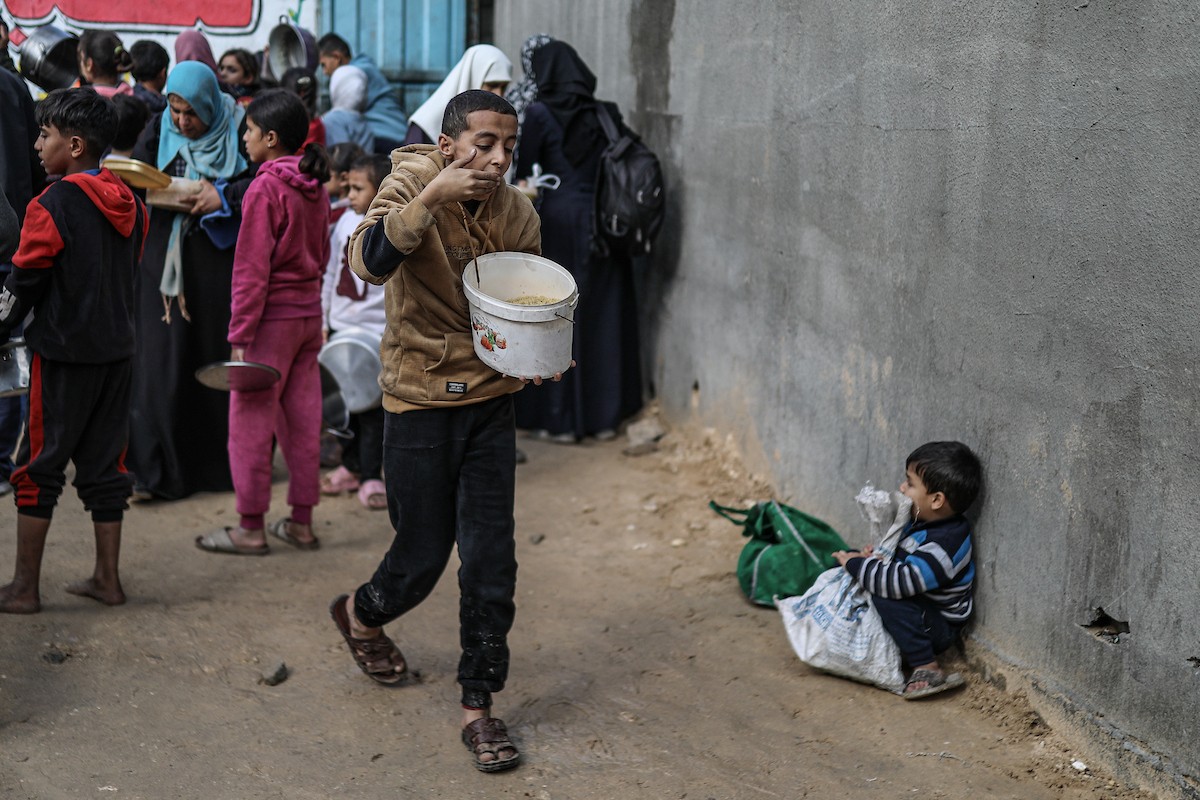 يصطفّ فلسطينيون لتلقّي الطعام من مطبخ خيري في تجمع للنازحين بمخيم النصيرات للاجئين، وسط قطاع غزة. ١٧ ديسمبر/كانون الأول ٢٠٢٥. تصوير: رمزي أبو عامر / (apa)