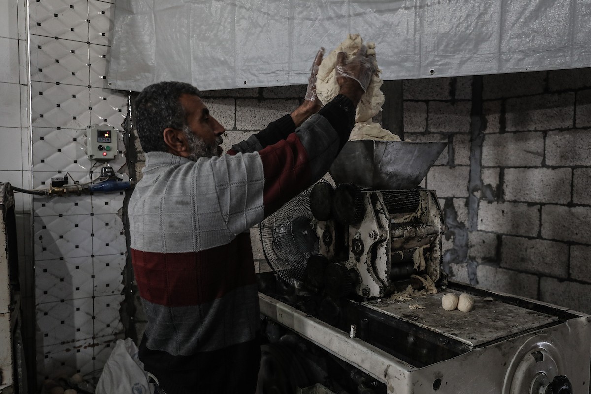 عمال فلسطينيون يعيدون تشغيل أحد أقدم المخابز في مخيم النصيرات للاجئين بعد إغلاقه لمدة عامين بسبب الحرب (15).jpg