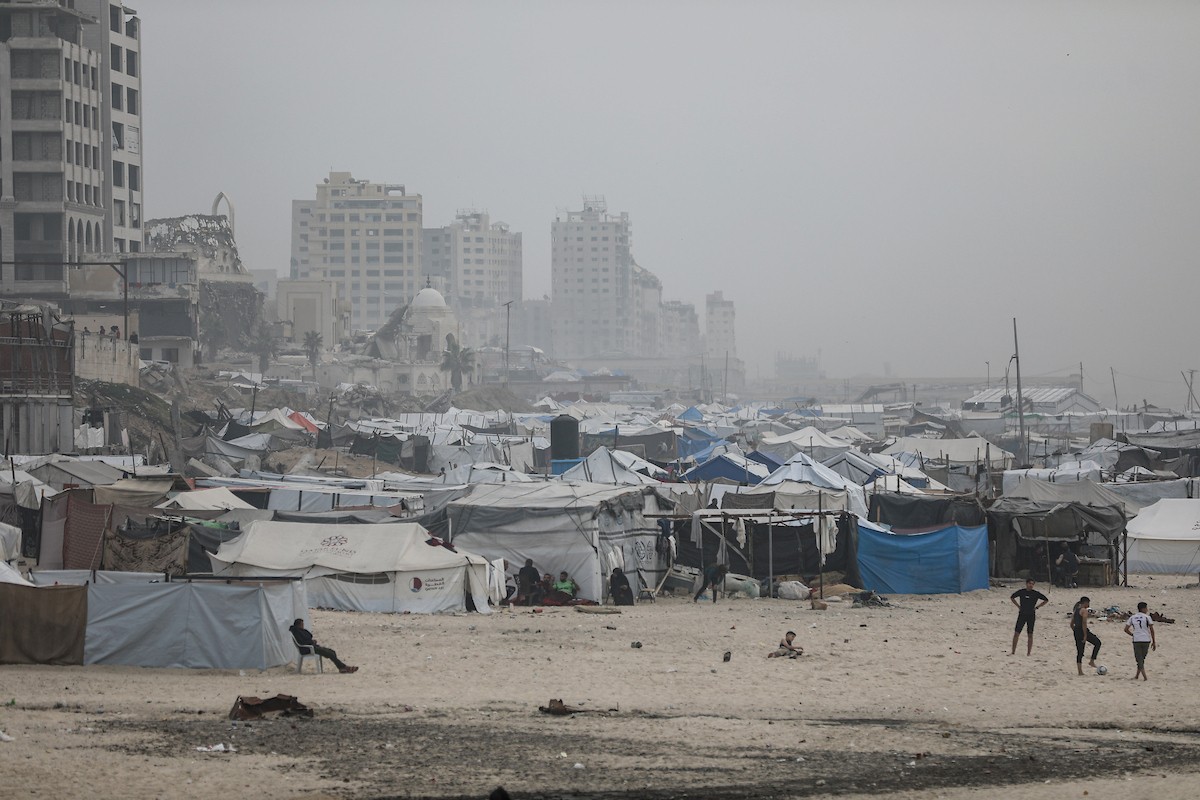 يقضي فلسطينيون نازحون وقتًا على الشاطئ مقابل خيامهم الممتدة على طول ميناء غزة، في غزة، 5 ديسمبر/كانون الأول 2025. تصوير: عمر أشتوي