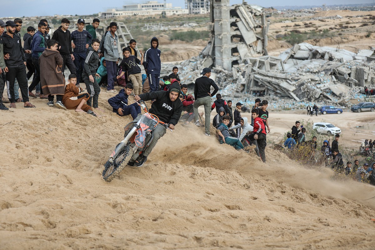 شبان فلسطينيون يركبون الدراجات النارية على الكثبان الرملية في بلدة الزهراء، بعد انقطاع دام عامين عن هذه الرياضة بسبب الحرب واحتلال الجيش الإسرائيلي للمنطقة المعروفة سابقا بمحور