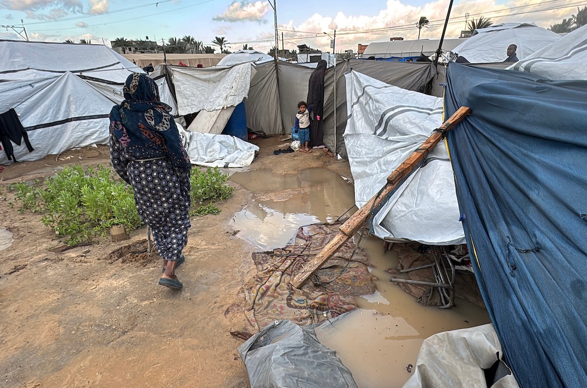 يُكافح الفلسطينيون النازحون، المقيمون في خيام مؤقتة، من أجل البقاء في ظل ظروف قاسية، حيث تجتاح الأمطار والعواصف الشديدة دير البلح، وسط قطاع غزة، في 28 ديسمبركانون الأول 2025. صورة أحمد إبراهيم(APA)