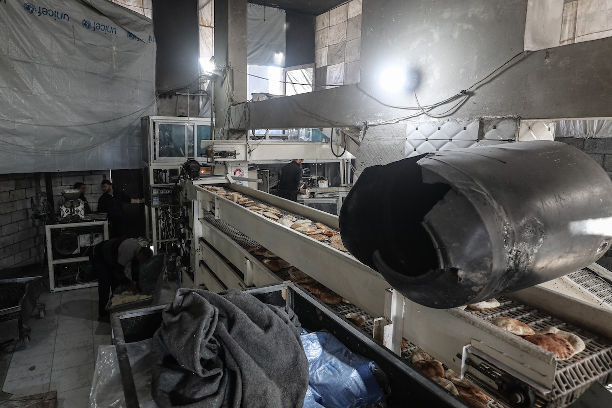 عمال فلسطينيون يعيدون تشغيل أحد أقدم المخابز في مخيم النصيرات للاجئين بعد إغلاقه لمدة عامين بسبب الحرب (18).jpg