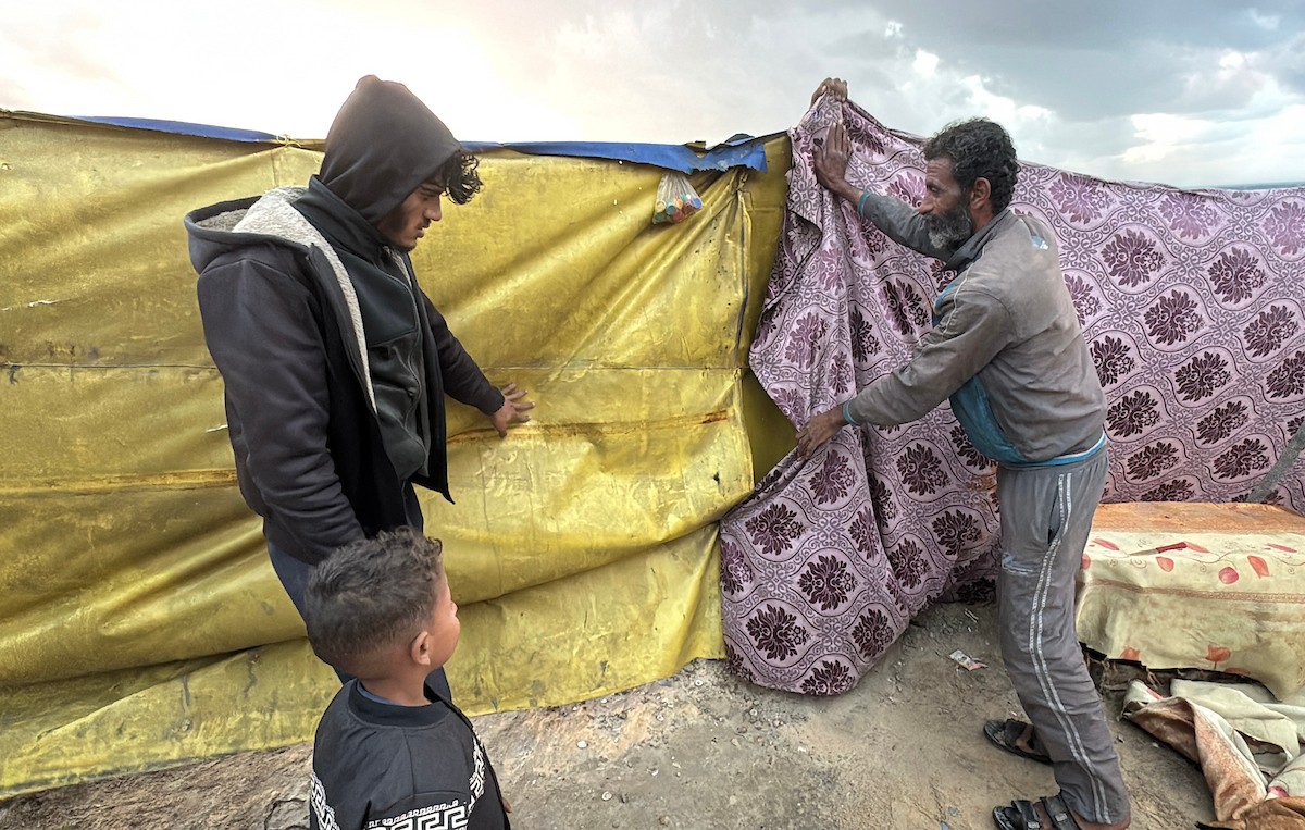 يُكافح الفلسطينيون النازحون، المقيمون في خيام مؤقتة، من أجل البقاء في ظل ظروف قاسية، حيث تجتاح الأمطار والعواصف الشديدة دير البلح، وسط قطاع غزة، في 28 ديسمبركانون الأول 2025. صورة أحمد إبراهيم(APA)