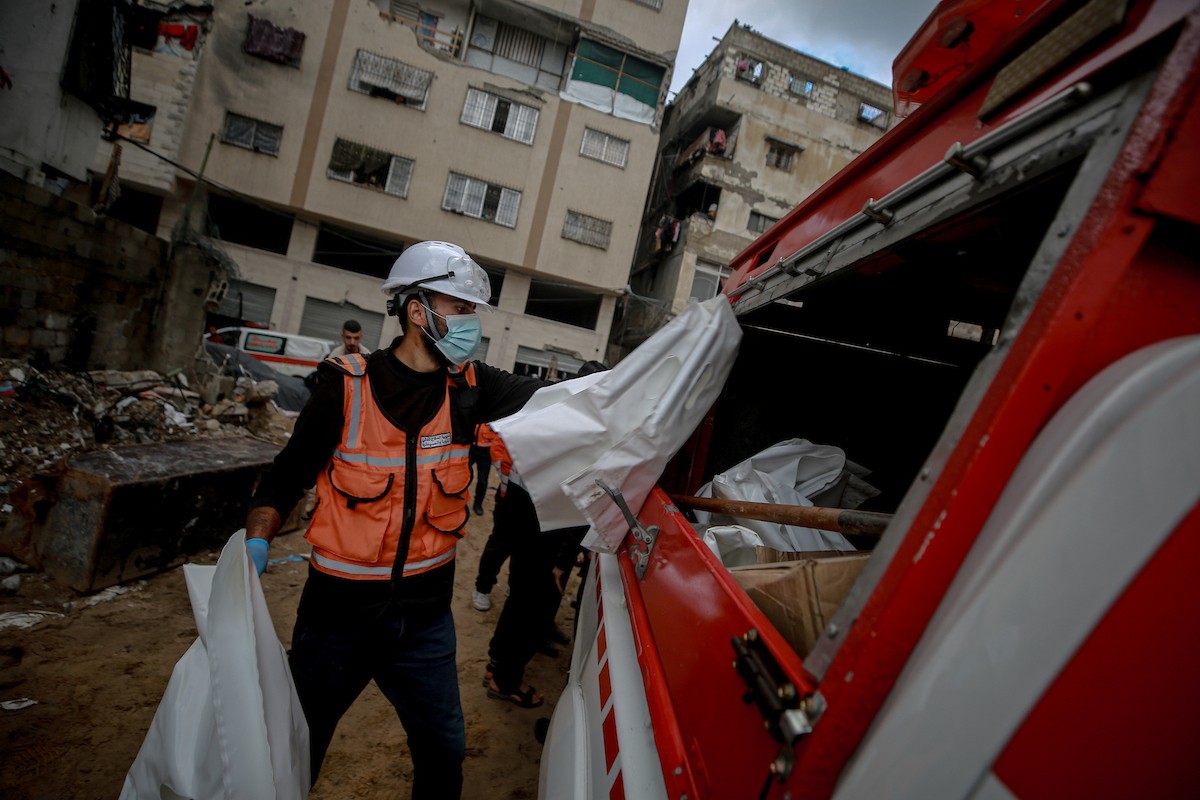 عمال الدفاع المدني الفلسطيني يبحثون عن جثث في مبنى منهار يعود لعائلة سالم، استُهدف بغارات إسرائيلية في بداية الحرب، في شارع الجلاء بمدينة غزة، يوم الاثنين 15 ديسمبر/كانون الأول 2025. صورة: عمر أشتوي