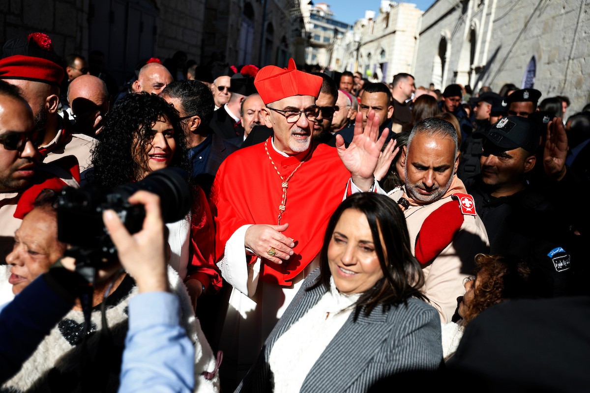 البطريرك اللاتيني للقدس، الكاردينال الإيطالي بييرباتيستا بيتسابالا يستقبل الحجاج والسياح لدى وصوله لترؤس قداس منتصف الليل في كنيسة المهد بمدينة بيت لحم، 24 ديسمبر/كانون الأول 2025،  (صور: مأمون وزواز/ apa)