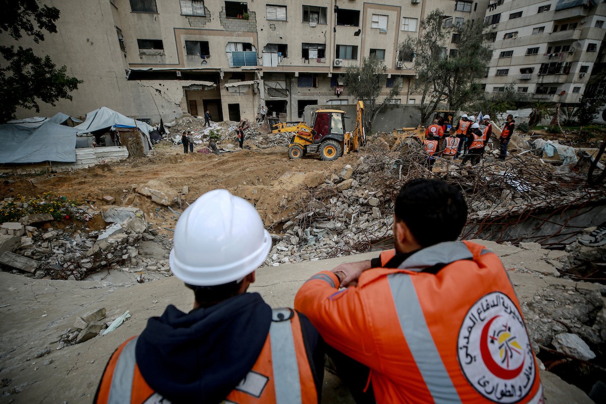 عمال الدفاع المدني الفلسطيني يبحثون عن جثث في مبنى منهار يعود لعائلة سالم، استُهدف بغارات إسرائيلية في بداية الحرب، في شارع الجلاء بمدينة غزة، يوم الاثنين 15 ديسمبر/كانون الأول 2025. صورة: عمر أشتوي