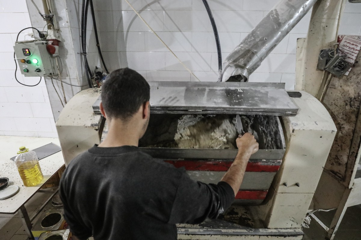 عمال فلسطينيون يعيدون تشغيل أحد أقدم المخابز في مخيم النصيرات للاجئين بعد إغلاقه لمدة عامين بسبب الحرب (28).jpg