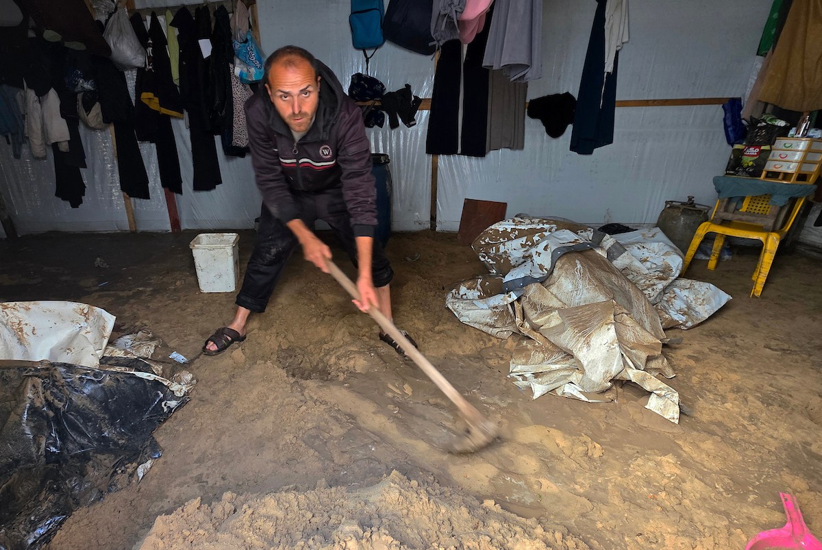 يُكافح الفلسطينيون النازحون، المقيمون في خيام مؤقتة، من أجل البقاء في ظل ظروف قاسية، حيث تجتاح الأمطار والعواصف الشديدة منطقة المواصي، غرب خان يونس، جنوب قطاع غزة، في 28 ديسمبر/كانون الأول 2025. (صورة: طارق محمد)