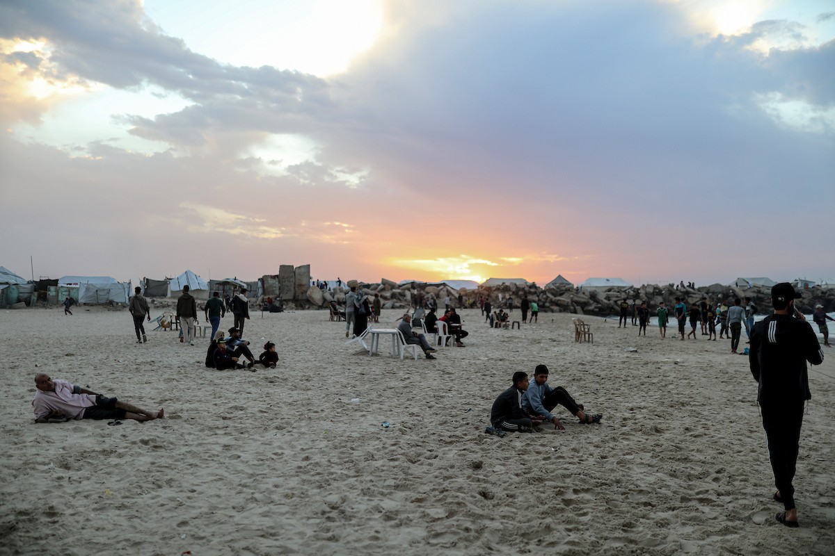 يقضي فلسطينيون نازحون وقتًا على الشاطئ مقابل خيامهم الممتدة على طول ميناء غزة، في غزة، 5 ديسمبر/كانون الأول 2025. تصوير: عمر أشتوي