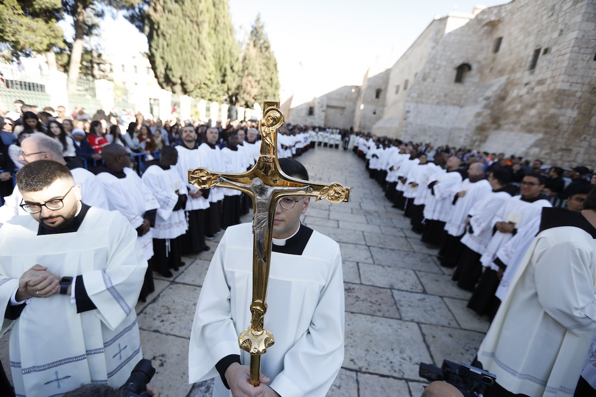 البطريرك اللاتيني للقدس، الكاردينال الإيطالي بييرباتيستا بيتسابالا يستقبل الحجاج والسياح لدى وصوله لترؤس قداس منتصف الليل في كنيسة المهد بمدينة بيت لحم، 24 ديسمبر/كانون الأول 2025،  (صور: مأمون وزواز/ apa)