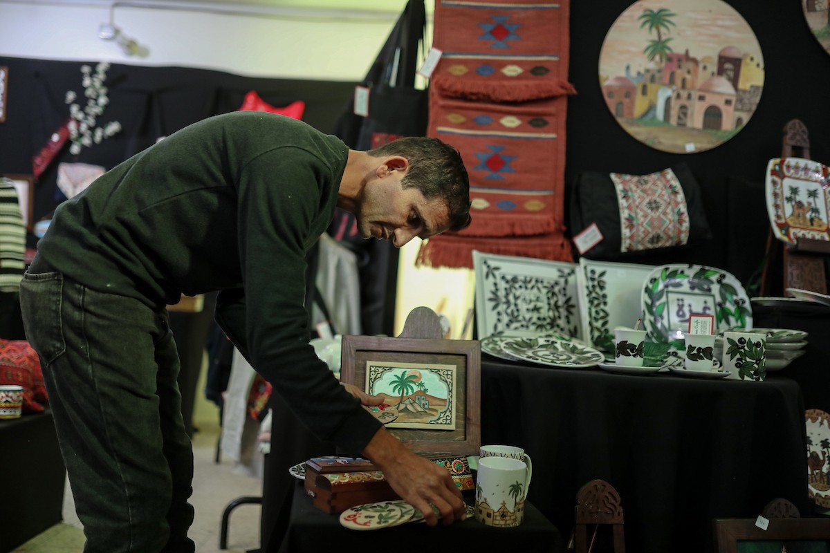 فلسطينيون يحضرون معرضًا يعرض منتجات يدوية من صنع مجموعة من الحرفيين الصم في مدينة غزة