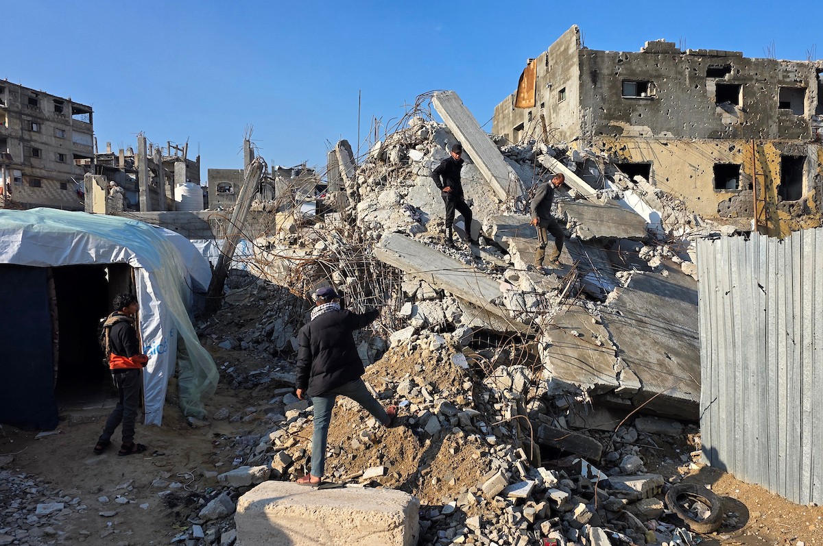 الفلسطيني هشام أبو عية يبني مأوى مؤقت لعائلته المكونة من ثمانية أفراد باستخدام قضبان حديدية استخرجها من أنقاض منزله الذي دُمر في هجمات إسرائيلية بمنطقة بطن السمين في خان يونس،  19 ديسمبر/كانون الأول 2025. تصوير: طارق محمد/ (APA )