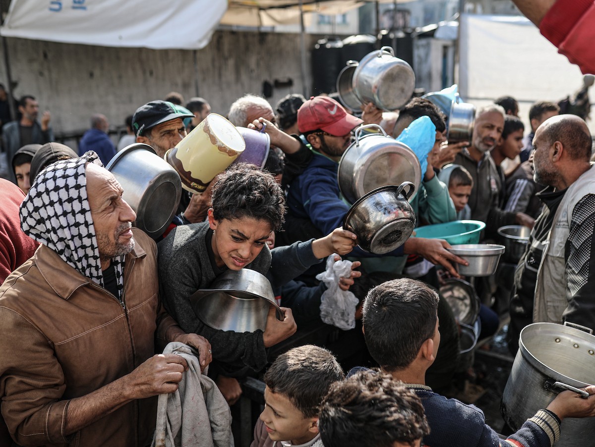 يصطفّ فلسطينيون لتلقّي الطعام من مطبخ خيري في تجمع للنازحين بمخيم النصيرات للاجئين، وسط قطاع غزة. ١٧ ديسمبر/كانون الأول ٢٠٢٥. تصوير: رمزي أبو عامر / (apa)