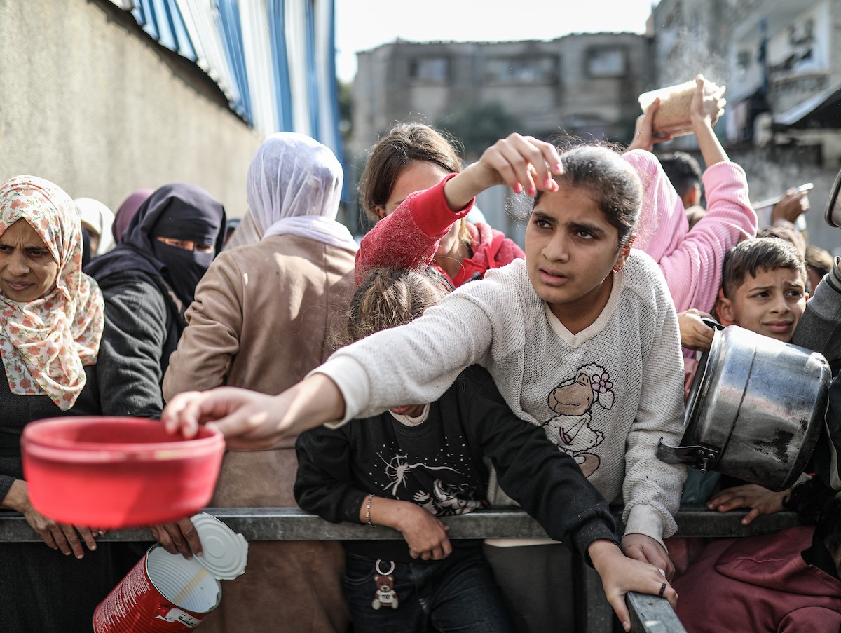 يصطفّ فلسطينيون لتلقّي الطعام من مطبخ خيري في تجمع للنازحين بمخيم النصيرات للاجئين، وسط قطاع غزة. ١٧ ديسمبر/كانون الأول ٢٠٢٥. تصوير: رمزي أبو عامر / (apa)