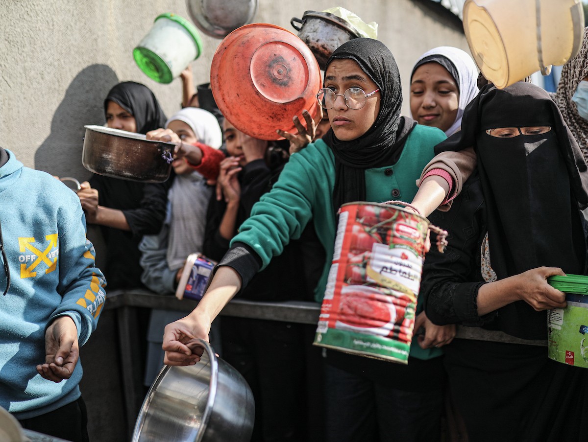 يصطفّ فلسطينيون لتلقّي الطعام من مطبخ خيري في تجمع للنازحين بمخيم النصيرات للاجئين، وسط قطاع غزة. ١٧ ديسمبر/كانون الأول ٢٠٢٥. تصوير: رمزي أبو عامر / (apa)