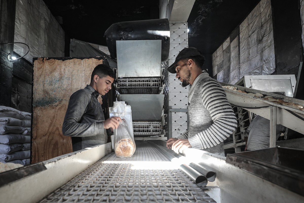 عمال فلسطينيون يعيدون تشغيل أحد أقدم المخابز في مخيم النصيرات للاجئين بعد إغلاقه لمدة عامين بسبب الحرب (21).jpg
