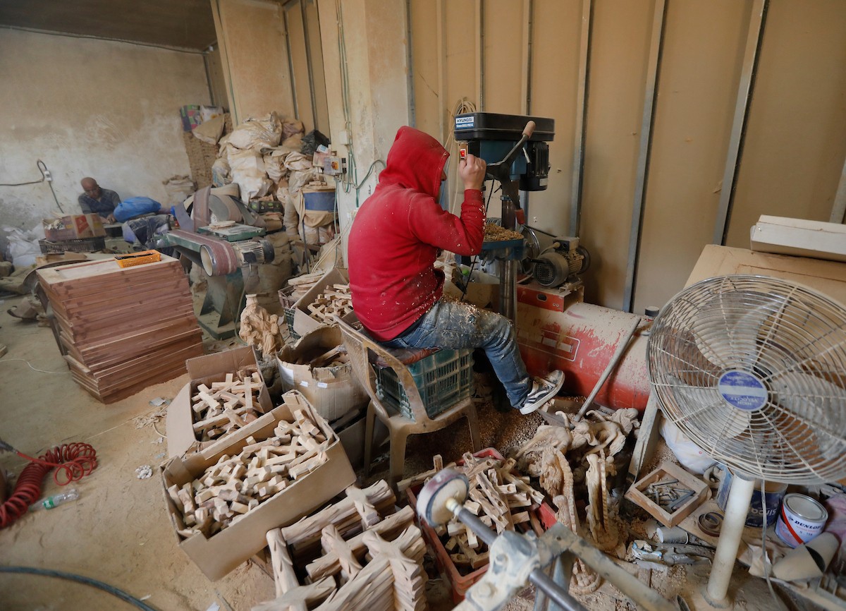 نحت خشب الزيتون في بيت لحم لصنع قطع فنية وهدايا متنوعة، تشمل منحوتات دينية وزخارف تقليدية وتذكارات، استعدادًا لعيد الميلاد، 18 ديسمبر/كانون الأول 2025 تصوير: مأمون وزواز/ (apa)