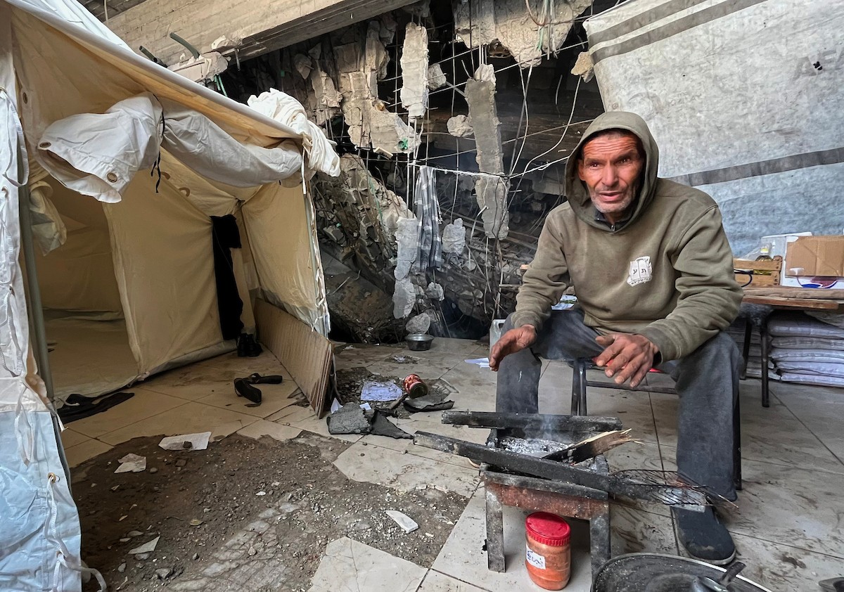 يعيش أشرف وشادية السرساوي مع أحفادهما العشرة داخل خيمة مؤقتة نُصبت في مبنى غير آمن إنشائياً غرب مدينة غزة، وسط تدهور الأوضاع الإنسانية.18 ديسمبر/كانون الأول 2025. صورة: مطر الزاق