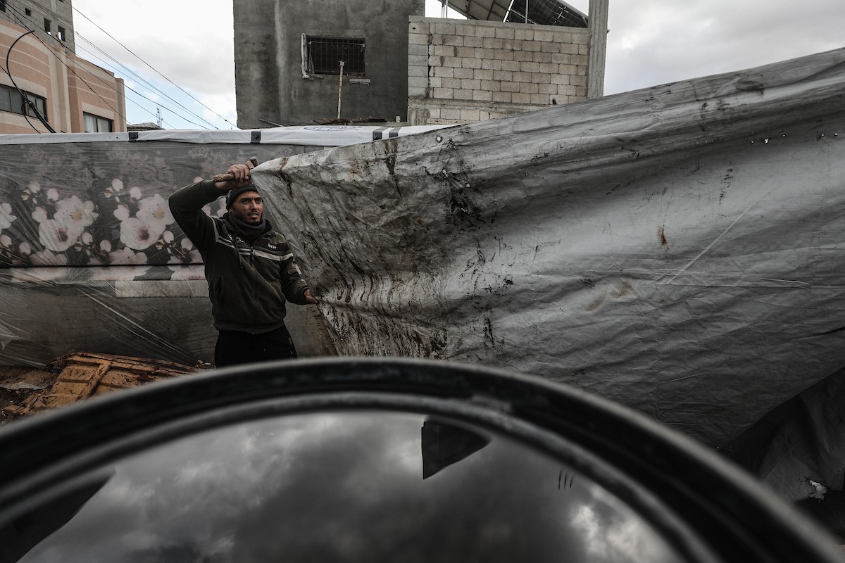 أحمد أبو ليلى أب لخمسة أطفال أصيب في الحرب  يحاول إصلاح خيمته بعد أن تضررت جراء الأمطار الغزيرة والرياح العاتية التي اجتاحت مخيم النصيرات وسط قطاع غزة، 28 ديسمبر/كانون الأول 2025.تصوير: معز صالحي