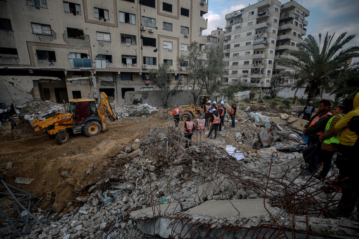 عمال الدفاع المدني الفلسطيني يبحثون عن جثث في مبنى منهار يعود لعائلة سالم، استُهدف بغارات إسرائيلية في بداية الحرب، في شارع الجلاء بمدينة غزة، يوم الاثنين 15 ديسمبر/كانون الأول 2025. صورة: عمر أشتوي