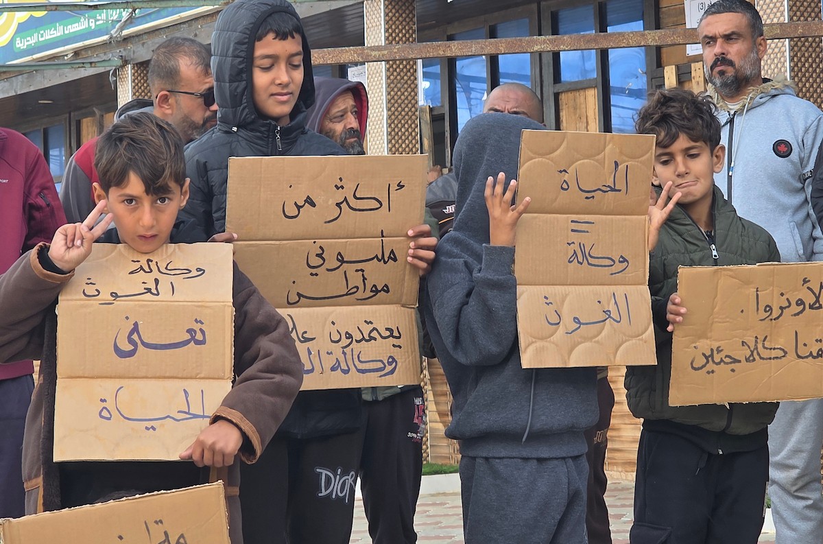 اعتصامٌ نظّمه ائتلاف رفح للنازحين أمام مقرّ الأونروا في منطقة فاش فرش، غرب رفح، للمطالبة بتفعيل الوكالة لدورها الإنساني، ولتسليط الضوء على معاناة النازحين ومطالبهم العادلة. رفح، جنوب قطاع غزة، 28 ديسمبر/كانون الأول 2025. تصوير: طارق محمد (APA ).