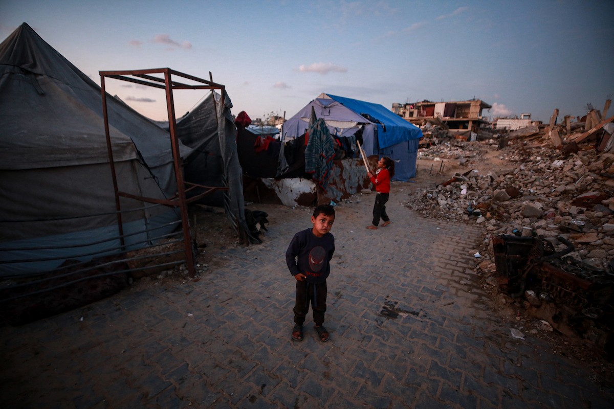 يحاول الفلسطينيون الحفاظ على حياتهم اليومية في مبانٍ مدمرة جزئيًا بعد أن غمرت الأمطار الغزيرة الخيام التي تؤوي نازحين في جباليا، شمال قطاع غزة، في 14 ديسمبر/كانون الأول 2025. صور: عمر أشتوي