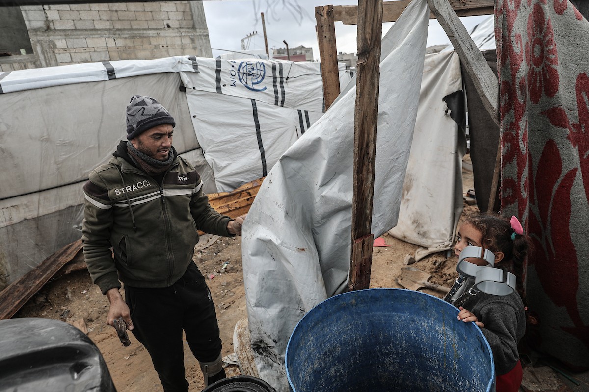 أحمد أبو ليلى أب لخمسة أطفال أصيب في الحرب  يحاول إصلاح خيمته بعد أن تضررت جراء الأمطار الغزيرة والرياح العاتية التي اجتاحت مخيم النصيرات وسط قطاع غزة، 28 ديسمبر/كانون الأول 2025.تصوير: معز صالحي