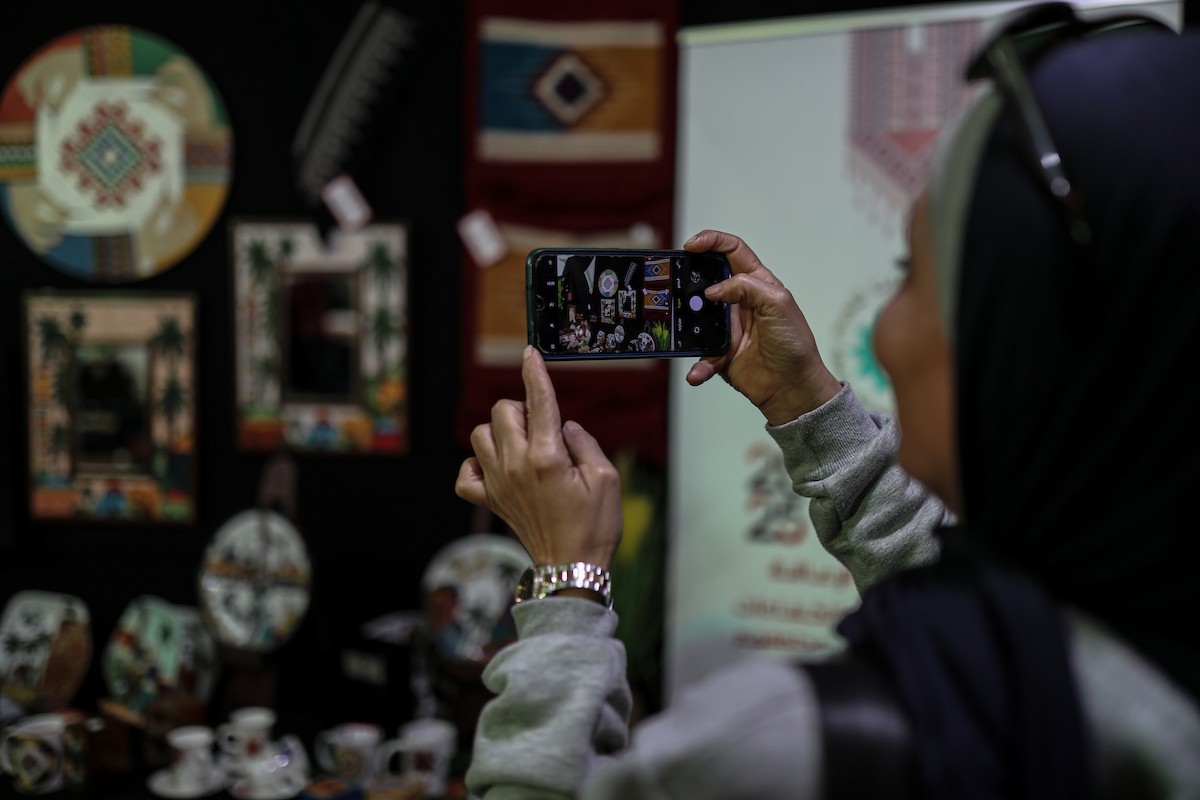 فلسطينيون يحضرون معرضًا يعرض منتجات يدوية من صنع مجموعة من الحرفيين الصم في مدينة غزة