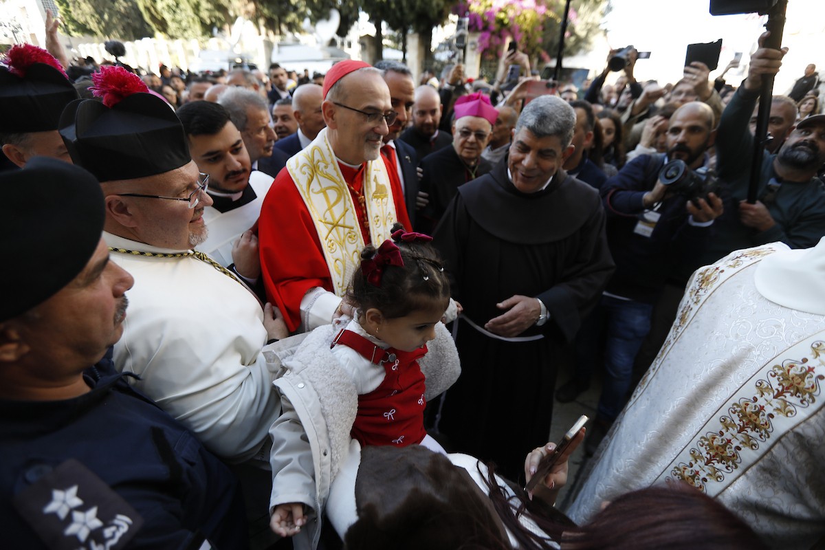 البطريرك اللاتيني للقدس، الكاردينال الإيطالي بييرباتيستا بيتسابالا يستقبل الحجاج والسياح لدى وصوله لترؤس قداس منتصف الليل في كنيسة المهد بمدينة بيت لحم، 24 ديسمبر/كانون الأول 2025،  (صور: مأمون وزواز/ apa)
