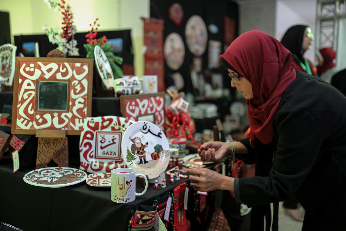 فلسطينيون يحضرون معرضًا يعرض منتجات يدوية من صنع مجموعة من الحرفيين الصم في مدينة غزة