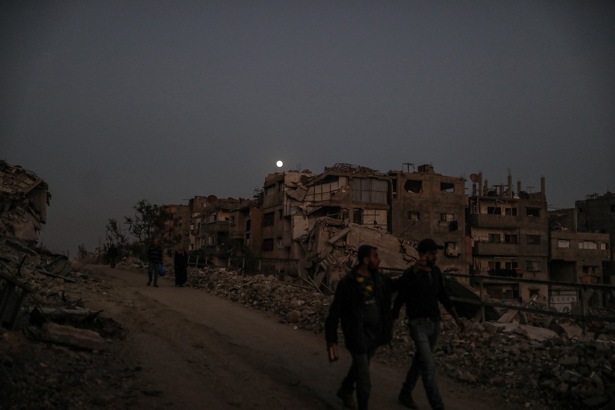 يعيش الفلسطينيون حياتهم اليومية ليلاً في خيام نصبت فوق أنقاض المباني المدمرة في حي الشيخ رضوان وسط مدينة غزة، 5 ديسمبر/كانون الأول 2025.تصوير: عمر أشتوي