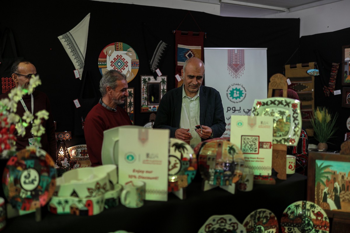 فلسطينيون يحضرون معرضًا يعرض منتجات يدوية من صنع مجموعة من الحرفيين الصم في مدينة غزة