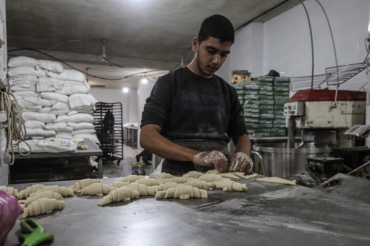 عمال فلسطينيون يعيدون تشغيل أحد أقدم المخابز في مخيم النصيرات للاجئين بعد إغلاقه لمدة عامين بسبب الحرب (4).jpg