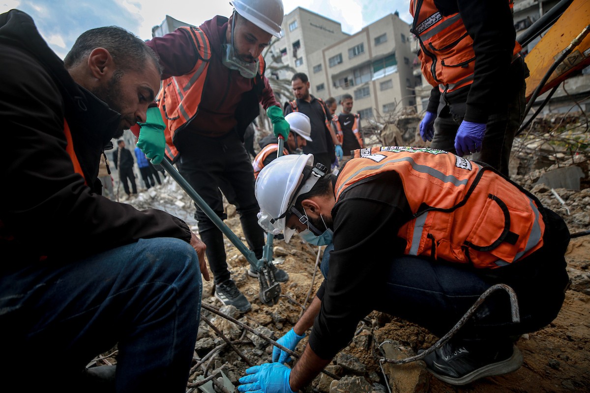 عمال الدفاع المدني الفلسطيني يبحثون عن جثث في مبنى منهار يعود لعائلة سالم، استُهدف بغارات إسرائيلية في بداية الحرب، في شارع الجلاء بمدينة غزة، يوم الاثنين 15 ديسمبر/كانون الأول 2025. صورة: عمر أشتوي