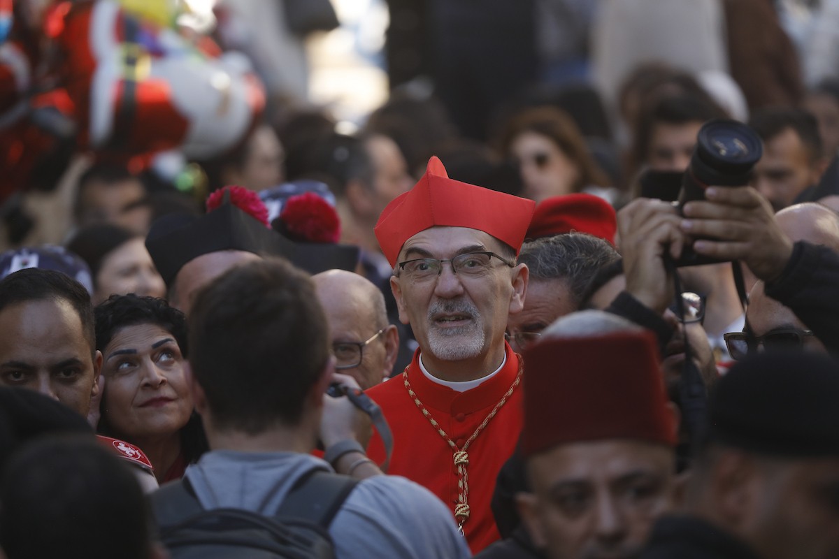 البطريرك اللاتيني للقدس، الكاردينال الإيطالي بييرباتيستا بيتسابالا يستقبل الحجاج والسياح لدى وصوله لترؤس قداس منتصف الليل في كنيسة المهد بمدينة بيت لحم، 24 ديسمبر/كانون الأول 2025،  (صور: مأمون وزواز/ apa)