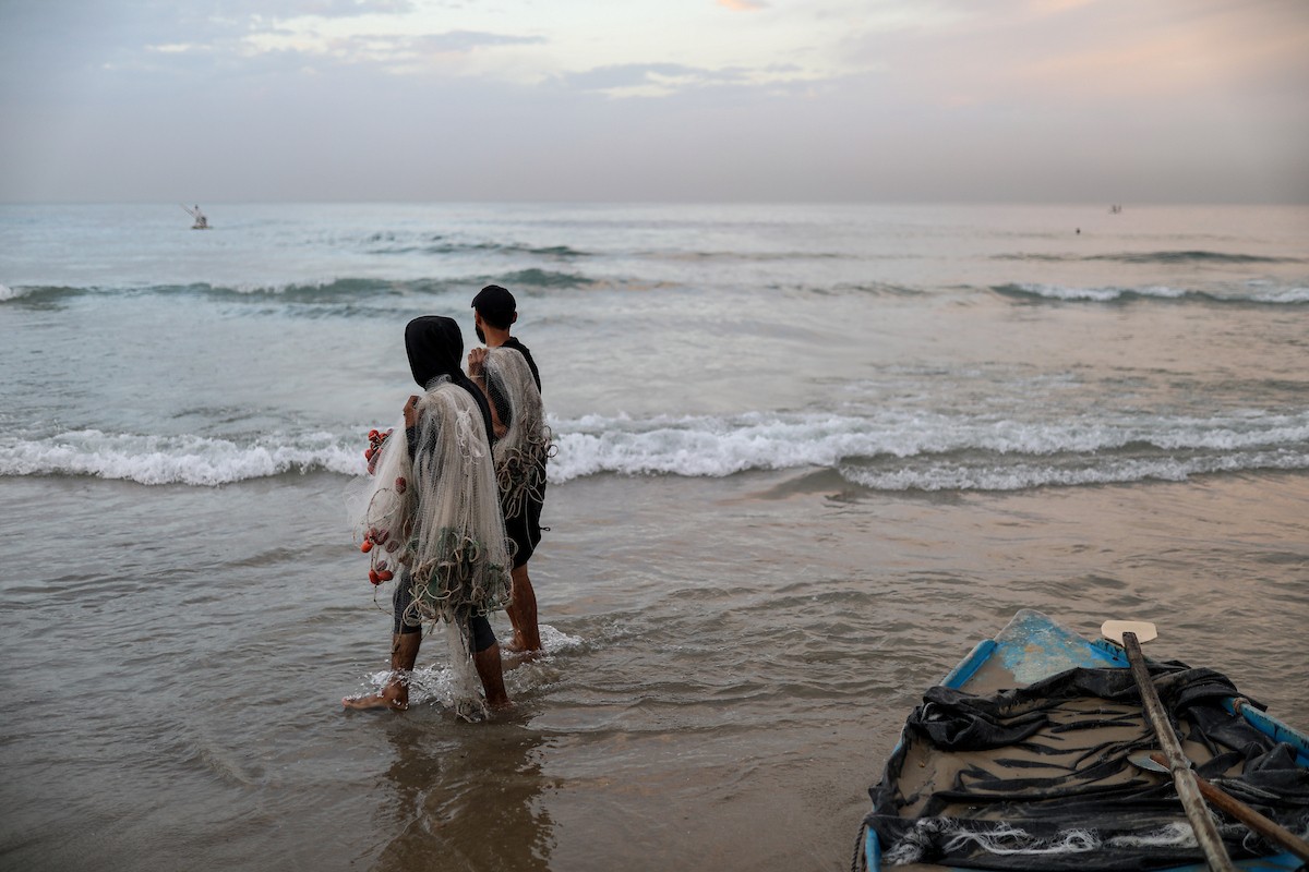 يقضي فلسطينيون نازحون وقتًا على الشاطئ مقابل خيامهم الممتدة على طول ميناء غزة، في غزة، 5 ديسمبر/كانون الأول 2025. تصوير: عمر أشتوي