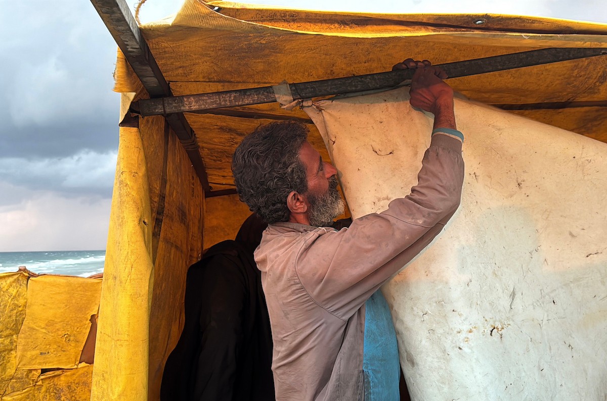 يُكافح الفلسطينيون النازحون، المقيمون في خيام مؤقتة، من أجل البقاء في ظل ظروف قاسية، حيث تجتاح الأمطار والعواصف الشديدة دير البلح، وسط قطاع غزة، في 28 ديسمبركانون الأول 2025. صورة أحمد إبراهيم(APA)