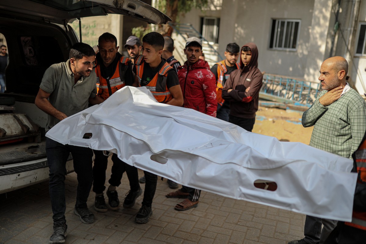 فلسطينيون ينعون ويحملون جثامين عدد من القتلى في غارة إسرائيلية على بيت لاهيا، بينهم أحد عناصر الدفاع المدني، خلال جنازة في مستشفى الشفاء بمدينة غزة