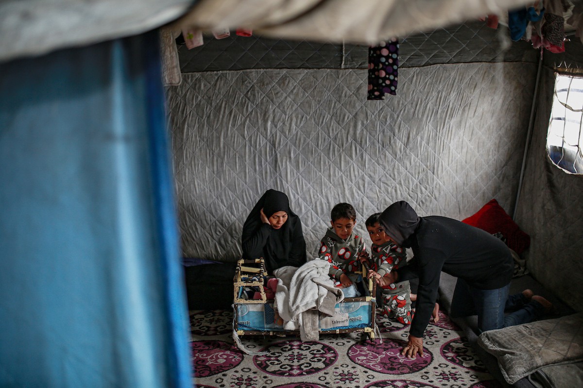 عائلة فلسطينية نازحة مكونة من ستة أفراد  تكافح وسط ظروف غير إنسانية من أجل حماية أطفالها من أجواء الشتاء القارس في  خيمة مهترئة بملعب اليرموك في مدينة غزة، 29 ديسمبر/كانون الأول 2025 صورة: عمر أشتوي