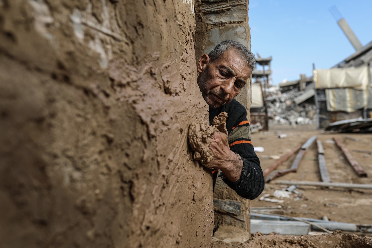 الفلسطيني أحمد المبحوح، مريض سرطان، يبني منزلاً طينياً بيديه في مخيم البريج للاجئين وسط قطاع غزة، 15 ديسمبر/كانون الأول 2025. عدسة: رمزي أبو عامر