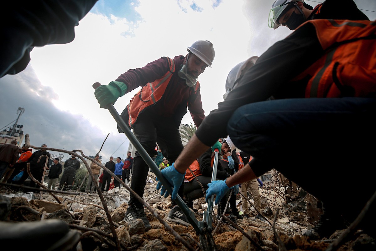 عمال الدفاع المدني الفلسطيني يبحثون عن جثث في مبنى منهار يعود لعائلة سالم، استُهدف بغارات إسرائيلية في بداية الحرب، في شارع الجلاء بمدينة غزة، يوم الاثنين 15 ديسمبر/كانون الأول 2025. صورة: عمر أشتوي