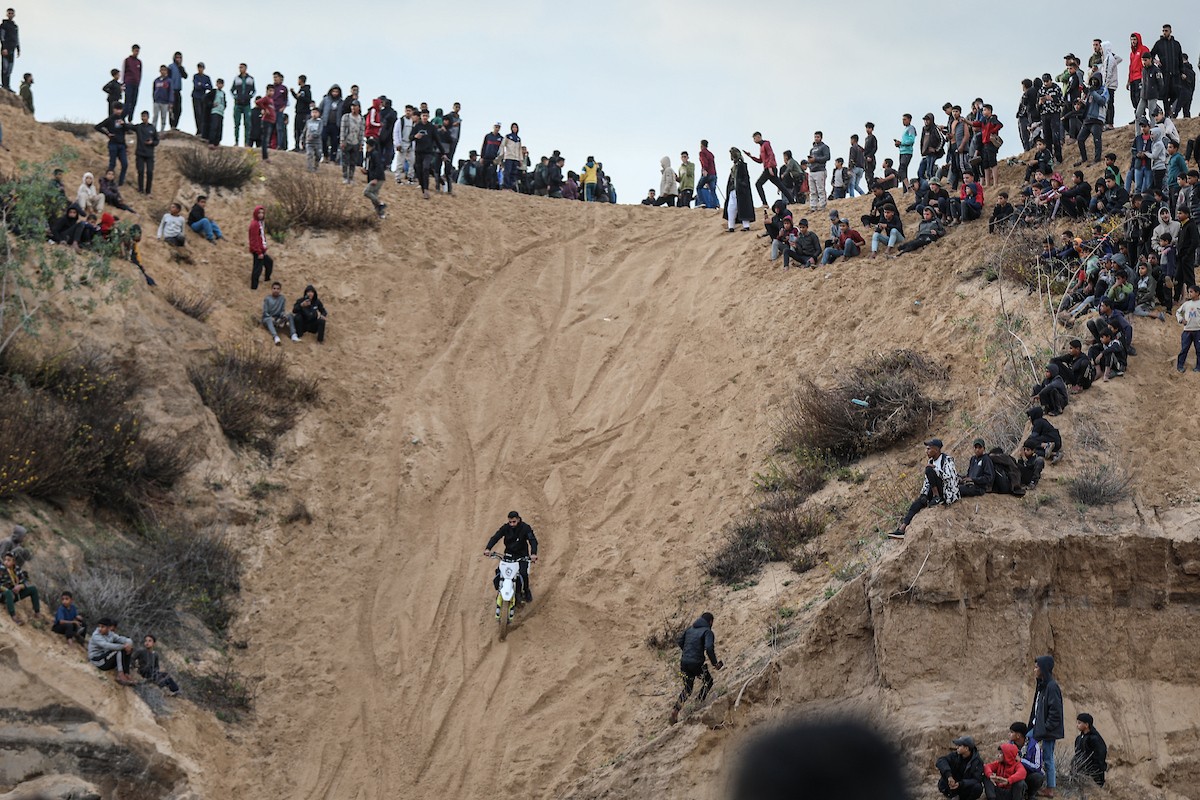 شبان فلسطينيون يركبون الدراجات النارية على الكثبان الرملية في بلدة الزهراء، بعد انقطاع دام عامين عن هذه الرياضة بسبب الحرب واحتلال الجيش الإسرائيلي للمنطقة المعروفة سابقا بمحور