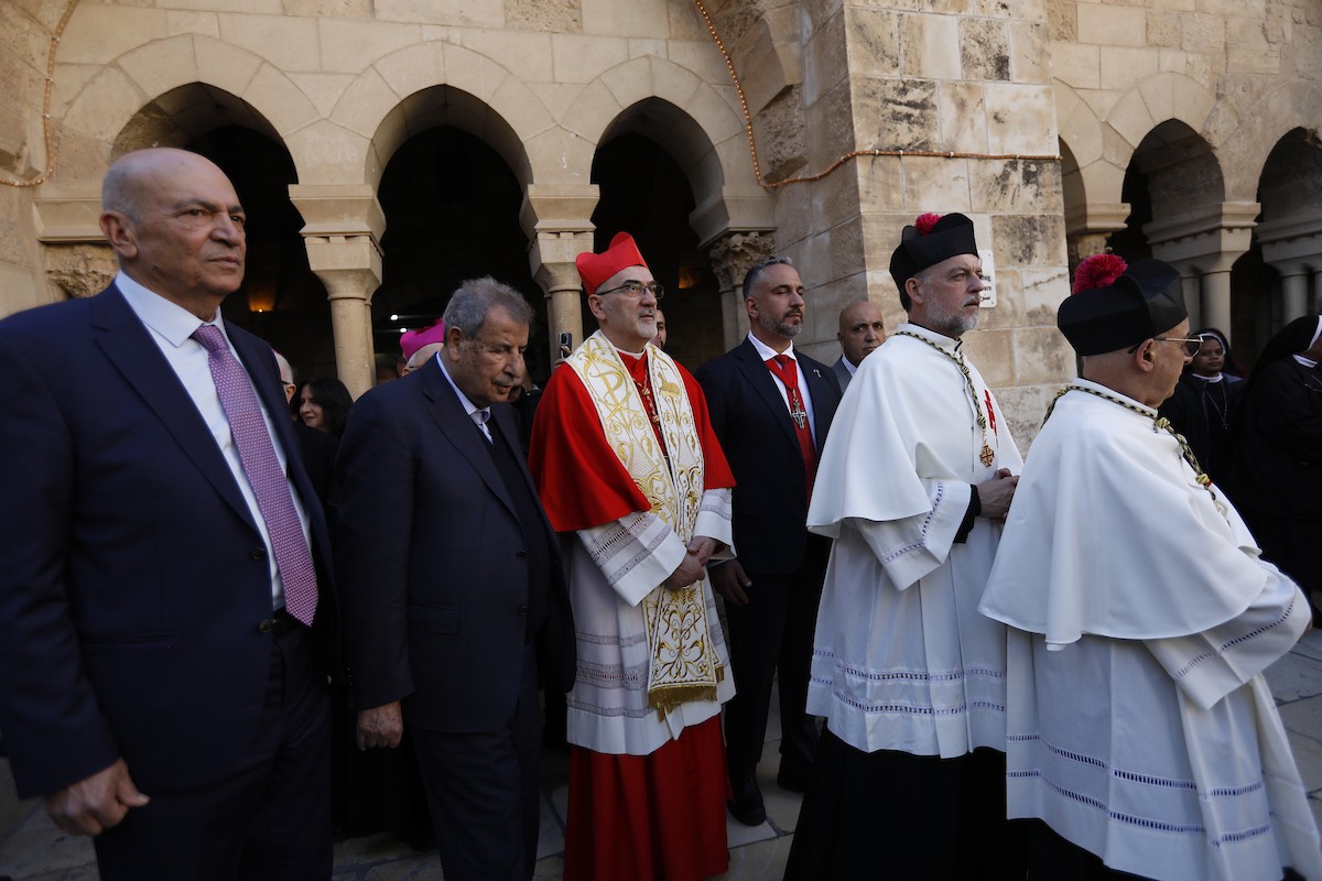 البطريرك اللاتيني للقدس، الكاردينال الإيطالي بييرباتيستا بيتسابالا يستقبل الحجاج والسياح لدى وصوله لترؤس قداس منتصف الليل في كنيسة المهد بمدينة بيت لحم، 24 ديسمبر/كانون الأول 2025،  (صور: مأمون وزواز/ apa)