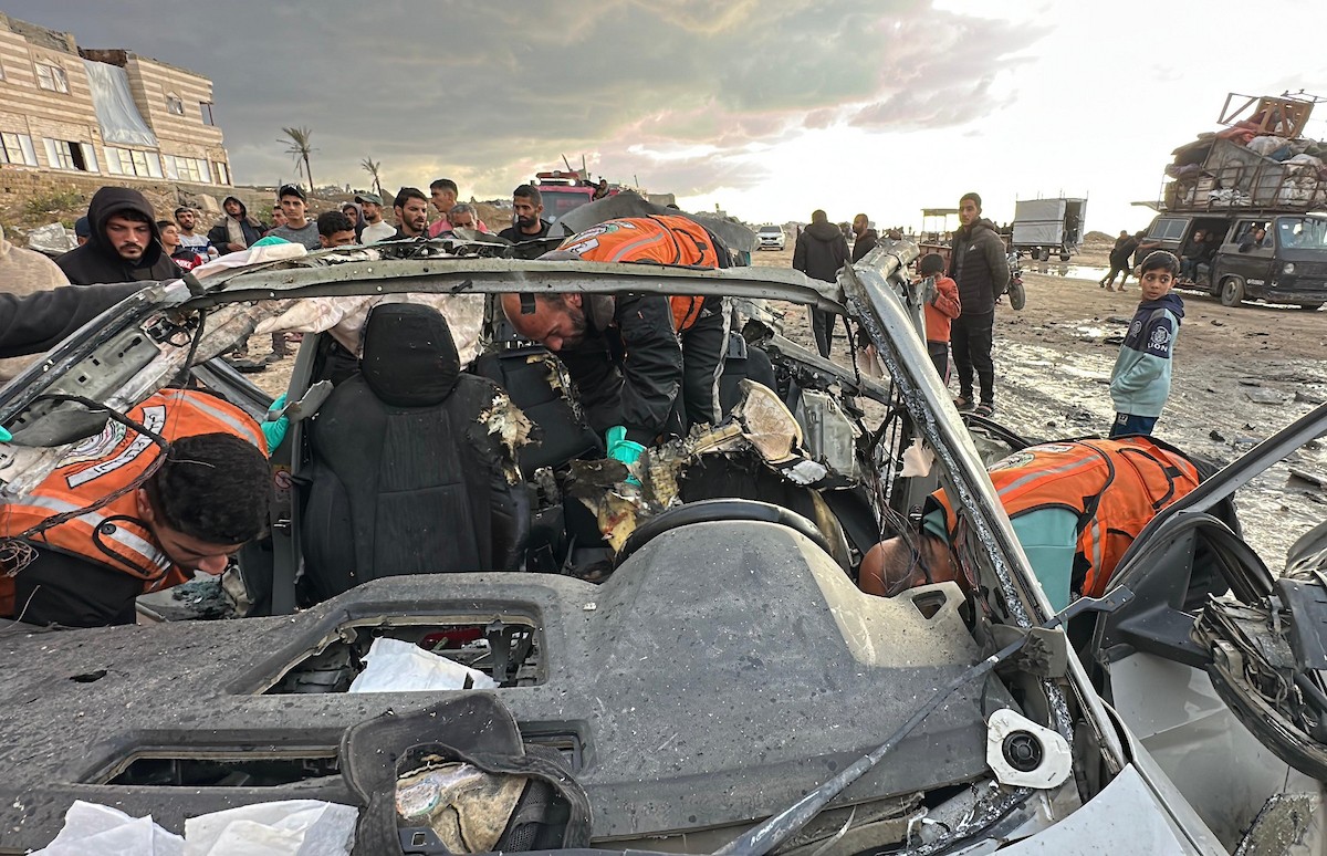 فلسطينيون يتفقدون موقع غارة إسرائيلية استهدفت سيارة على شارع لرشيد غرب مدينة غزة، 13 ديسمبر/كانون الأول 2025. صور: عمر أشتوي