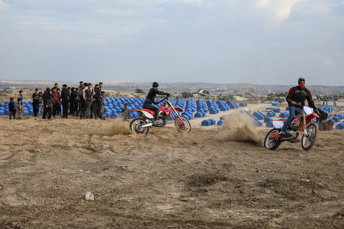 شبان فلسطينيون يركبون الدراجات النارية على الكثبان الرملية في بلدة الزهراء، بعد انقطاع دام عامين عن هذه الرياضة بسبب الحرب واحتلال الجيش الإسرائيلي للمنطقة المعروفة سابقا بمحور