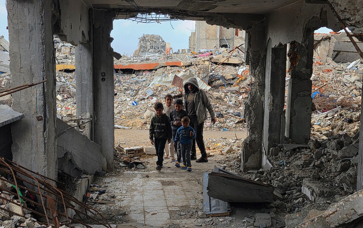 عائلة فلسطينية تحتمي من برد الشتاء القارس في خيمة نصبتها فوق منزلها المدمر قرب الخط الأصفر في خان يونس، جنوب قطاع غزة، ١٧ ديسمبر/كانون الأول ٢٠٢٥. تصوير: طارق محمد/وكالة الأنباء الفلسطينية (APA )